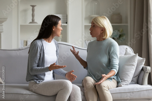 Angry grownup daughter and middle-aged mom dispute at home