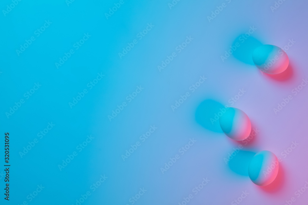 Egg hunt is coming. Easter traditions, pink-blue colored eggs on blue background, neon light top view, copyspace for ad. Concept of holidays, spring, celebrating, food and sweets, family time. Egg hunt is coming. Easter traditions, pink-blue colored eggs on blue background, neon light top view, copyspace for ad. Concept of holidays, spring, celebrating, food and sweets, family time.