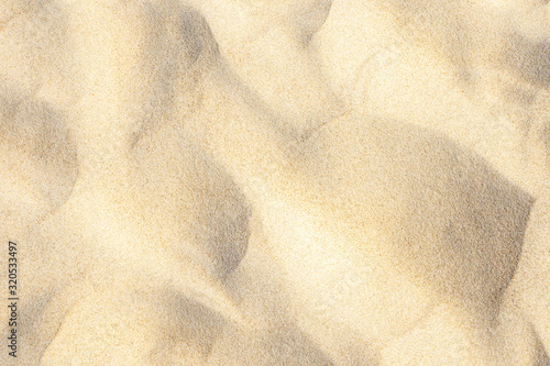 Light sand pattern on beach near sea in summer background