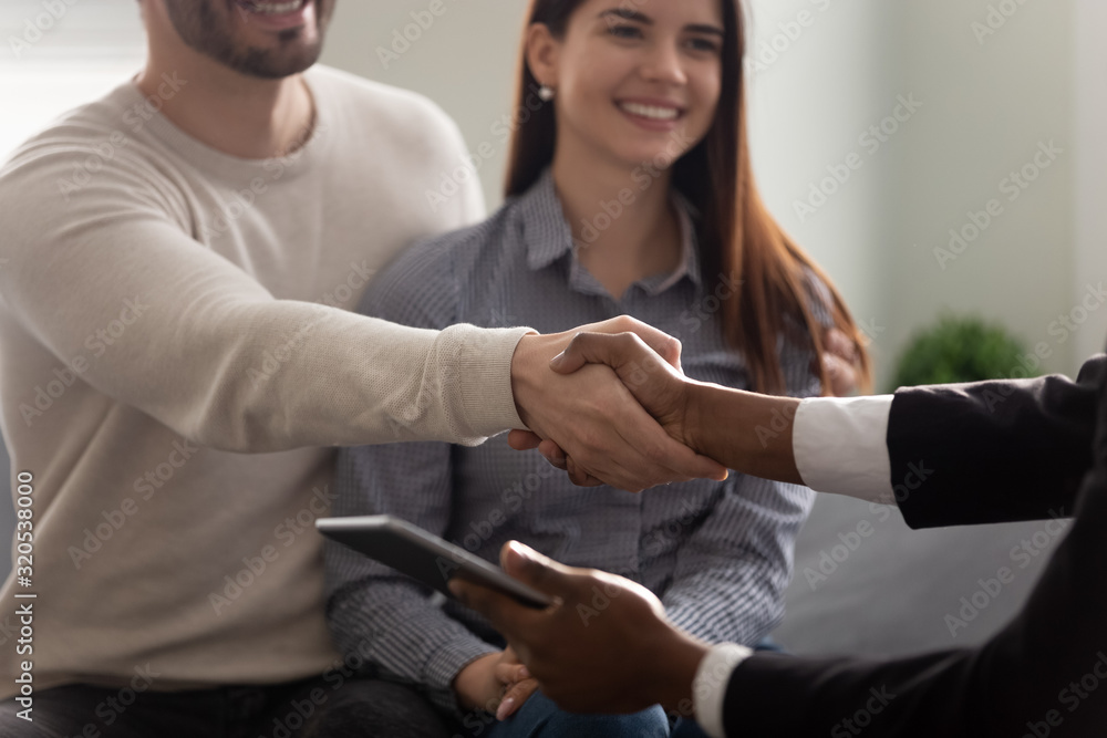Fototapeta premium Property buyer and African realtor handshaking greeting each other