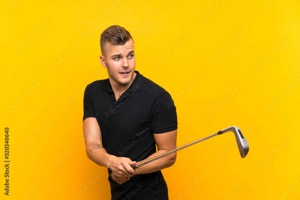 Golfer player man over isolated yellow background Golfer player man over isolated yellow background