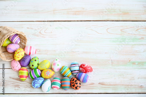 Easter eggs in the pouring basket or nest on rustic wooden background