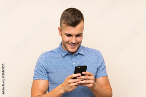 Happy Young blonde man using mobile phone © luismolinero