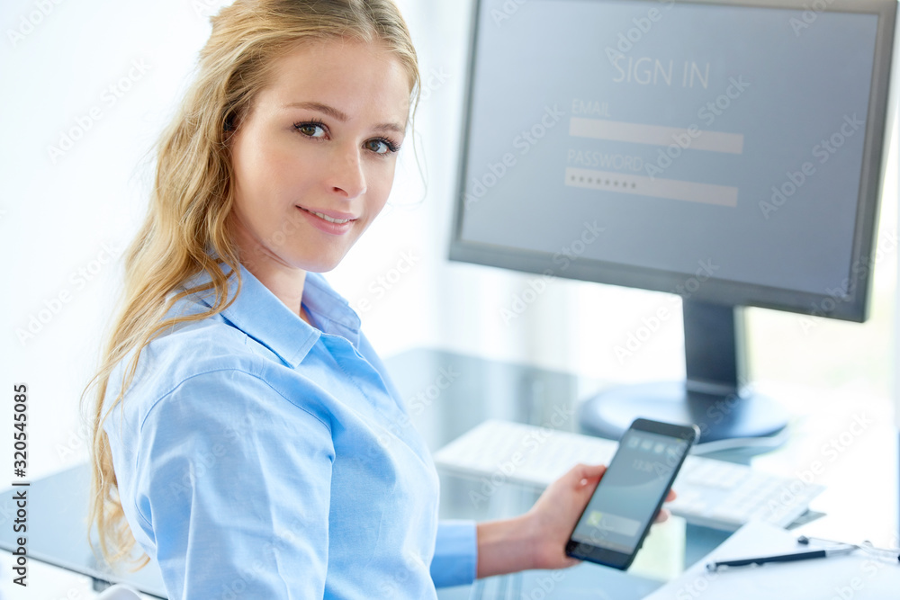 Businesswoman using her cell phone while working in the office Businesswoman using her cell phone while working in the office