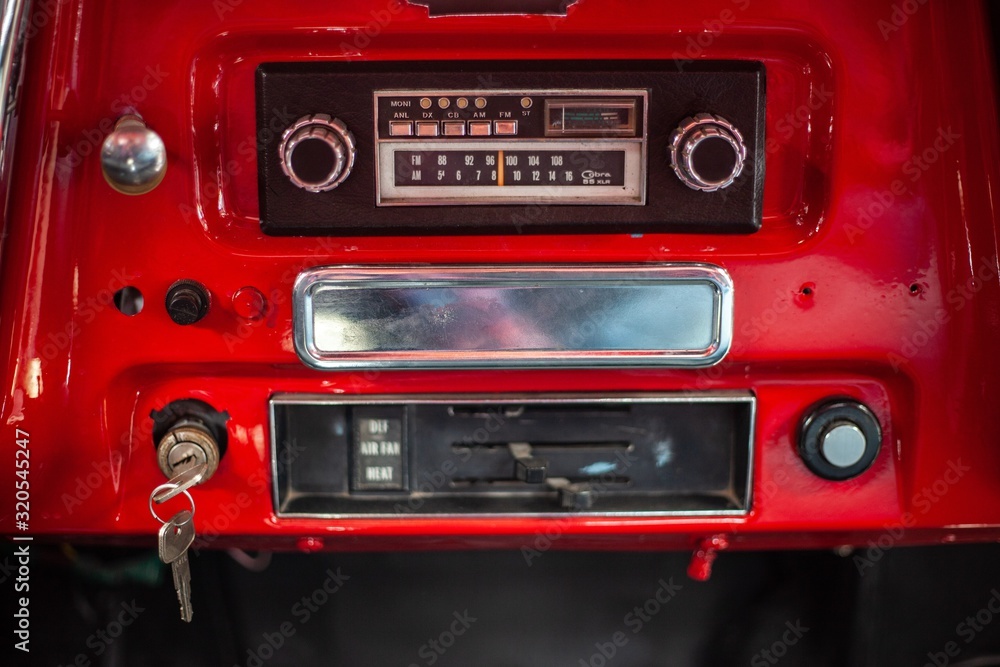 Fototapeta premium vintage radio in dashboard of red classic car
