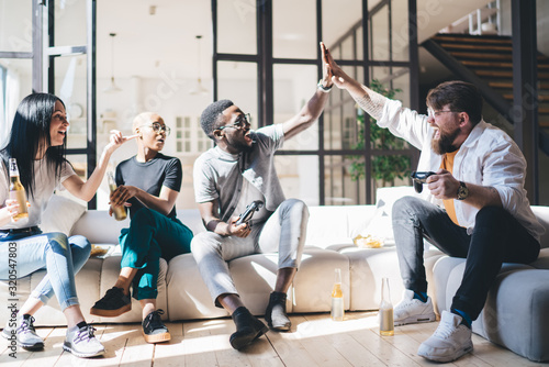 Foto Cheerful friends giving high five at home