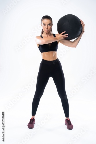Fit and strong female athlete working out with a medicine ball to get better core strength and stability