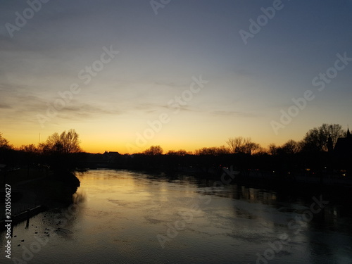  Sonnenuntergang auf einer Brücke auf einem Fluss im Winter