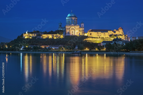 View of Esztergom Basilica from opposite bank of Danube in dusk, Hungary. The Primatial Basilica of Blessed Virgin Mary Assumed Into Heaven and St Adalbert is the biggest building in the country.