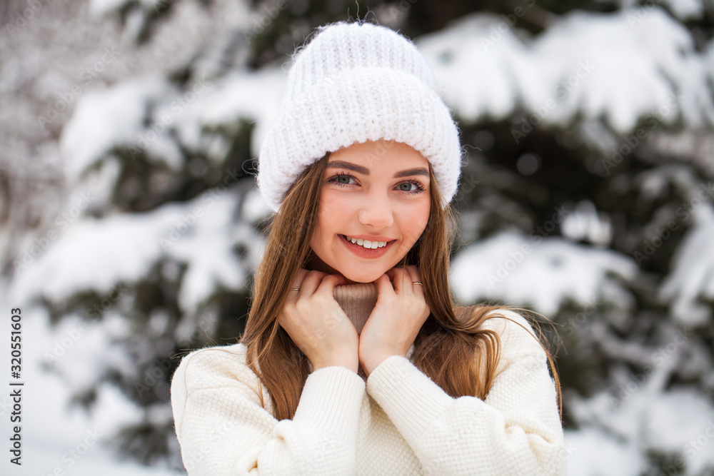 Young beautiful woman in a woolen sweater posing on a background of a winter park Young beautiful woman in a woolen sweater posing on a background of a winter park