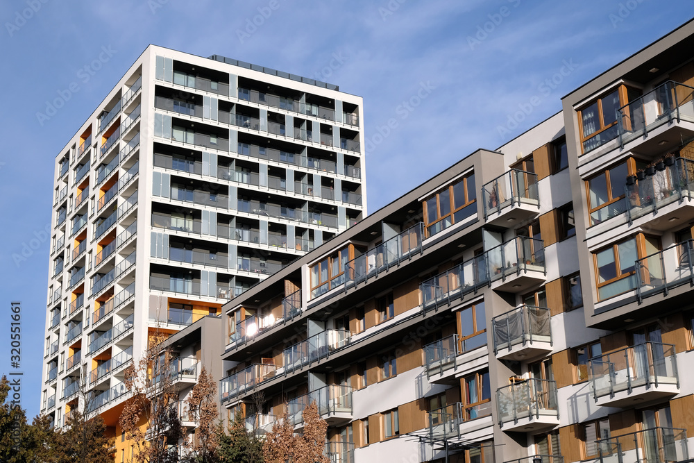 Exteriors of two modern apartment buildings with balcony in contemporary residential district.