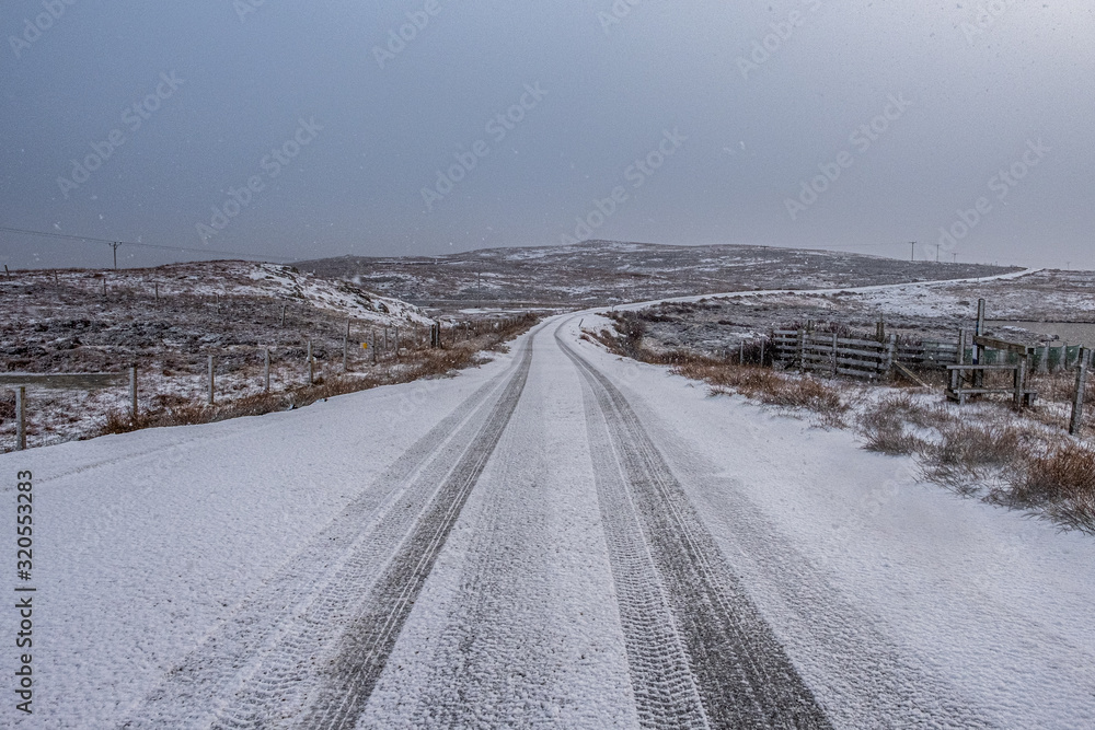 Snow falling on a rural road in winter