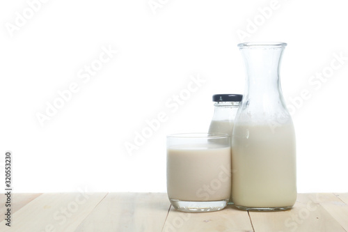 Milk in glass and in jar on table isolated on white background