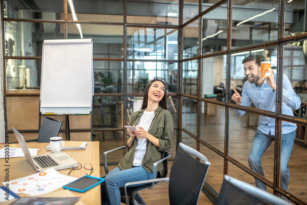 Two smiling office workers having fun during coffee break Two smiling office workers having fun during coffee break