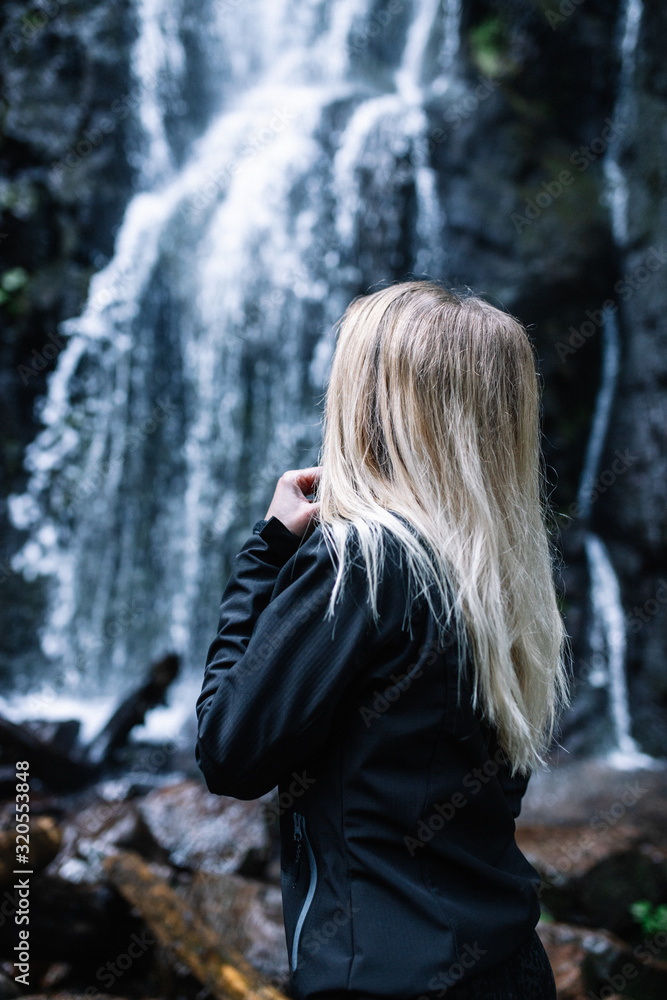 Close up of female adventurer standing near the waterfall in the Black Forest,Germany.