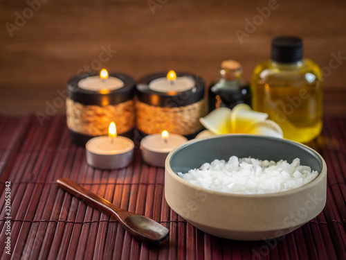 Spa pure mineral sea salts with bottles of massage oil and aromatheray candles  Thai style 