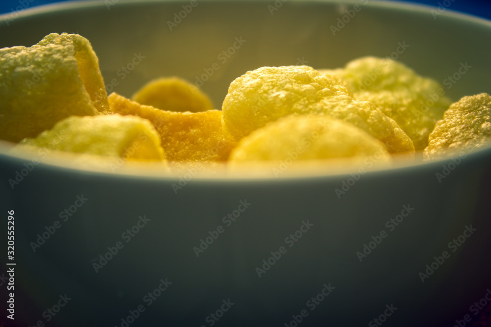Far-far (also fryum) in a bowl which is an Indian snack food composed primarily of potato starch and tinted sago.