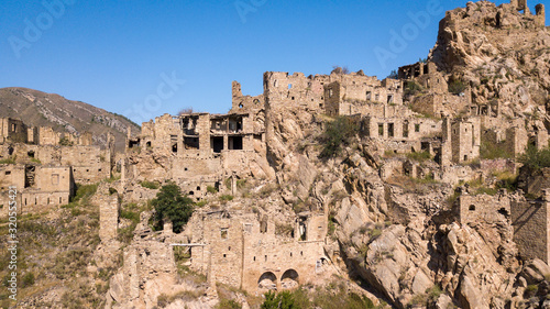 City - ghost, Dagestan, Russian - 1 SEPTEMBER, 2019: City of ancient ruins, city - ghost, mountainous area with green vegetation on background rocks, of blue sky and green forest