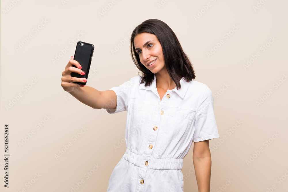 Young woman over isolated background making a selfie Young woman over isolated background making a selfie