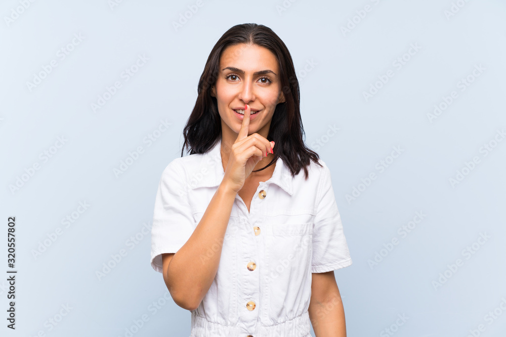 Young woman over isolated blue background doing silence gesture Young woman over isolated blue background doing silence gesture