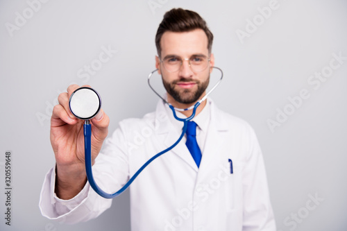 Close-up portrait of his he blurred nice attractive cheerful bearded doc listening your breath first aid help assistance patient visit cardiac center isolated on light white gray pastel color
