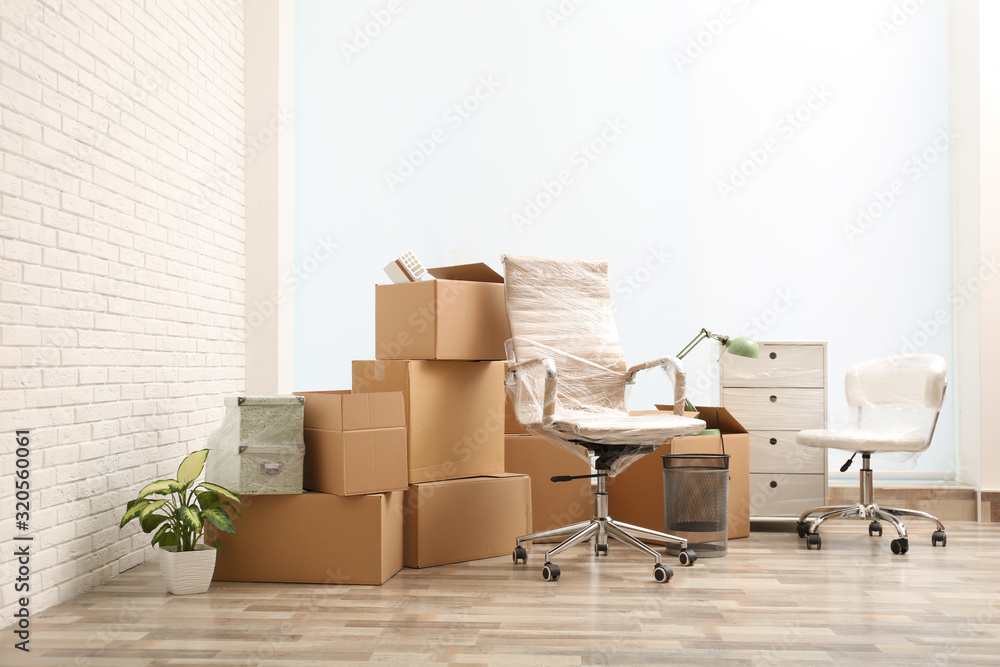 Moving boxes and stuff near white brick wall in room - obrazy, fototapety, plakaty 