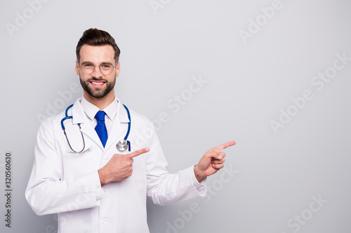 Close-up portrait of his he nice attractive confident cheerful cheery bearded guy pharmacy expert showing copy space new novelty product isolated on light white gray pastel color background