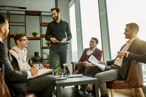 caucasian business team coworking in office, everyone in formal suits, young confident leaders 25 years old gathered to discuss deadlines, business startups and ideas.