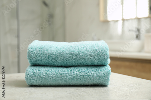 Stack of clean towels on table indoors