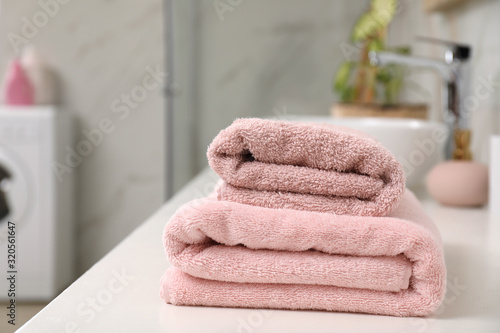 Stack of clean towels on bathroom countertop. Space for text