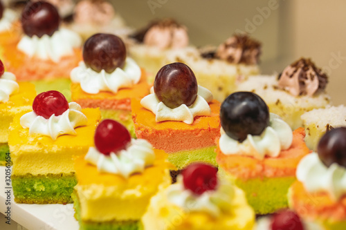 Closeup view photography of many small souffle cakes served on white plate on table for cocktail party or on shelves of store. photo