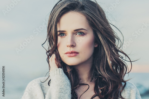 Attractive woman with long brown hair outdoor close up portrait