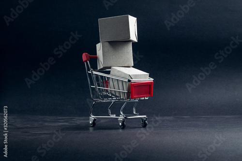 Shopping cart and box on dark background, business, shopping concept. Selective focus