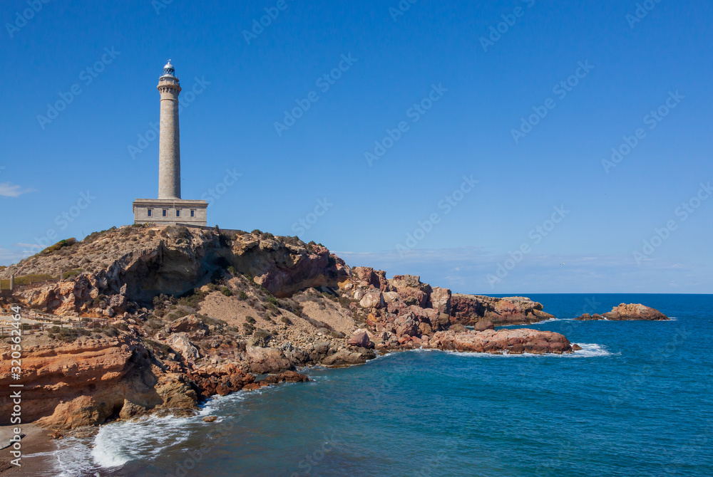 Cabo de Palos Lighthouse on the blue sky background, located on a small peninsula in Cartagena, Murcia, Spain