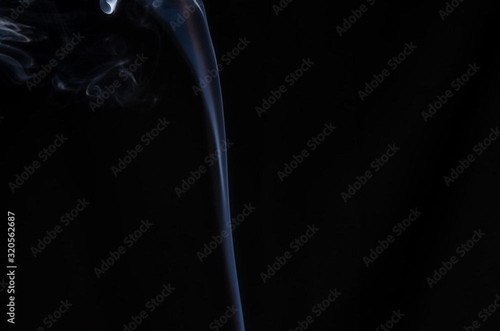 A thin stream of white smoke on a dark background with place for text, no people A thin stream of white smoke on a dark background with place for text, no people