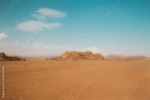 Sand dunes in Wadi RAM in the morning  Jordan.Pink sand in the desert. the mountains are located in the wasteland.Blue sky and beautiful weather for traveling through the beauty of red sand.Bedouin s