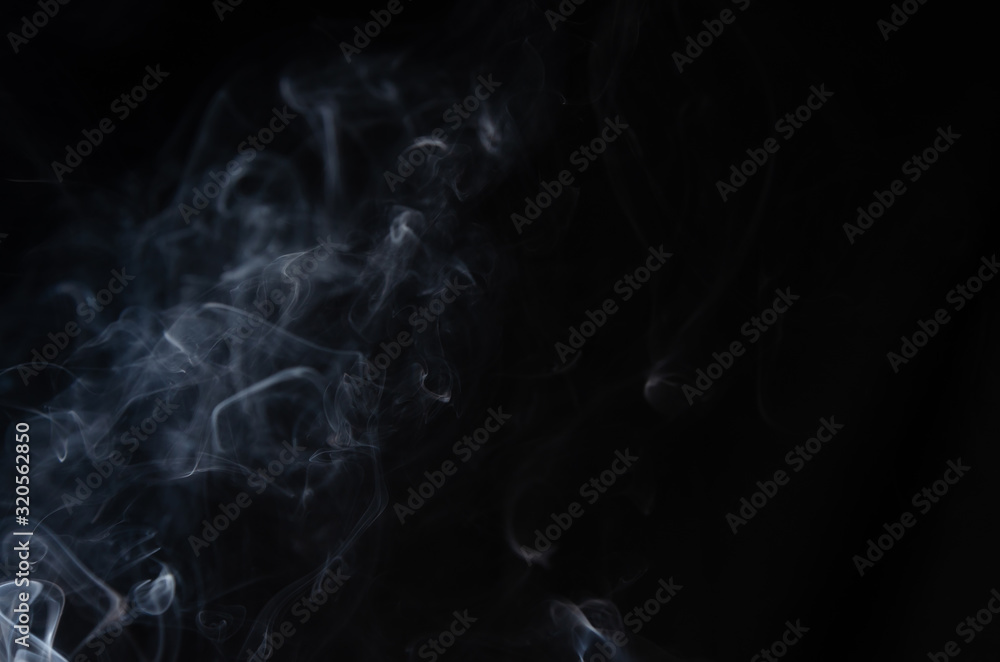 Abstract puffs of smoke on the left side of the frame on a dark background with a place for text, mysticism, fantasy Abstract puffs of smoke on the left side of the frame on a dark background with a place for text, mysticism, fantasy