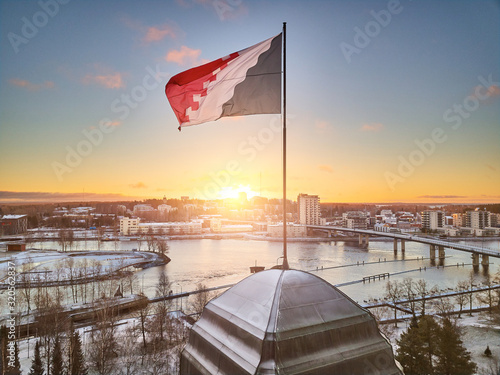 Aerial view of flag of North Karelia. Flag on the spire of City Hall. Joensuu, Finland in the morning in the first frost. In the background is the park and the Pielisjoki River. Bridge over the river. photo