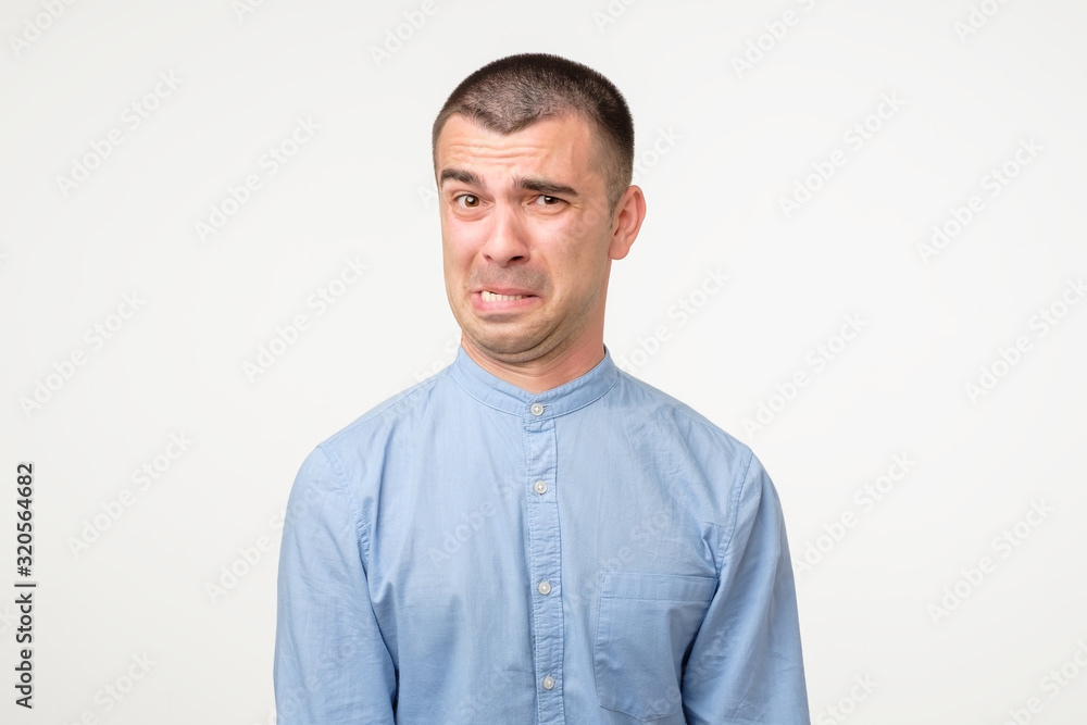 Funny young hispanic man showing cynical unhappy angry face Funny young hispanic man showing cynical unhappy angry face