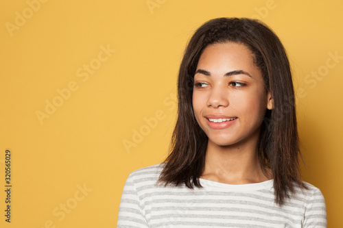 Young nice woman smiling on yellow studio background