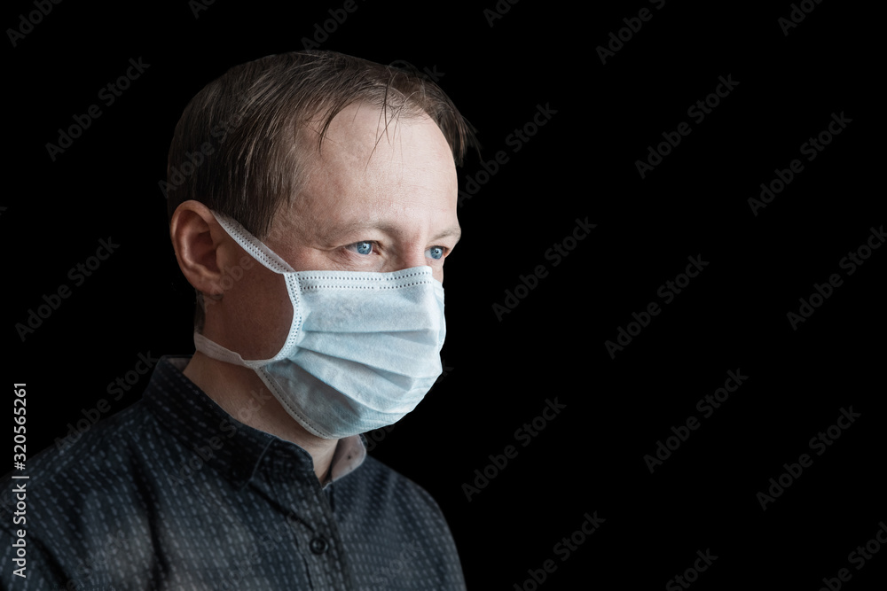 Man in a medical bandage on an isolated black background. Virus or dust protection concept. Coronavirus Man in a medical bandage on an isolated black background. Virus or dust protection concept. Coronavirus