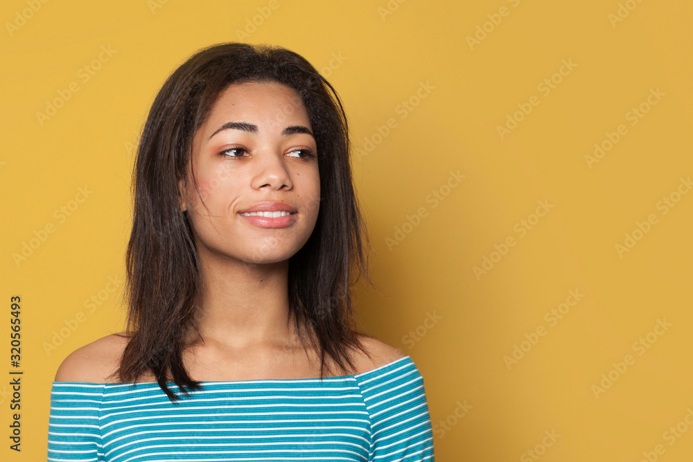 Happy black woman smiling on yellow background Happy black woman smiling on yellow background