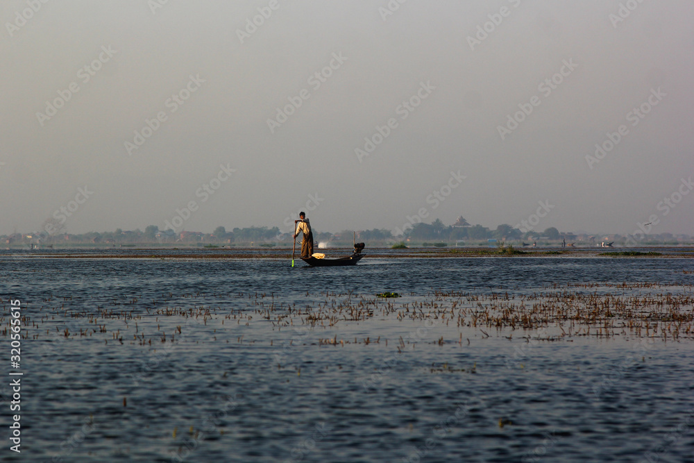 Φωτογραφία The fisherman of Inle Lake at sunrise establishes tackles