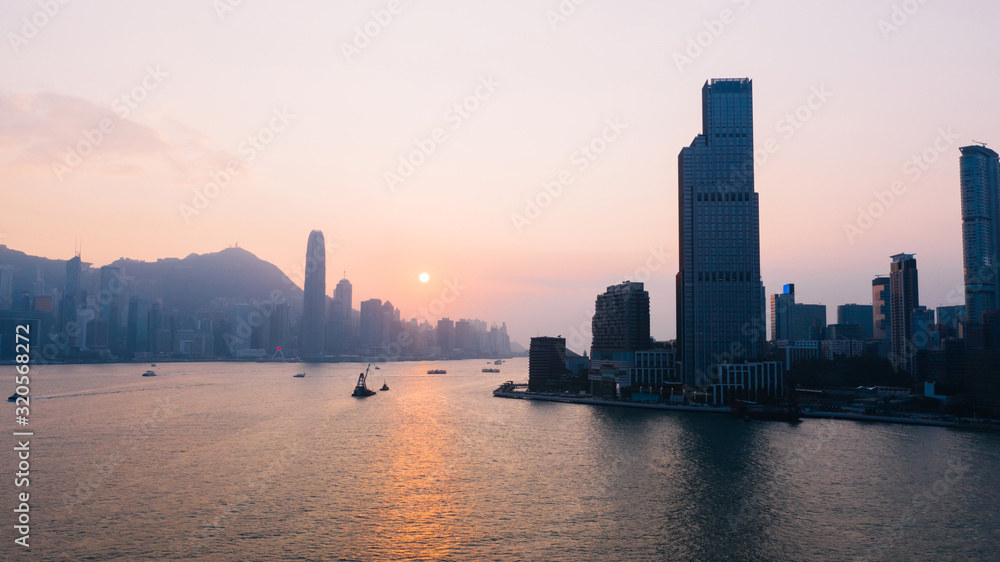 Aerial scenery panoramic view of Hong Kong Evening with metropolitan bay Victoria Harbor at sunset. Lighted Modern cityscape, urban skyline buildings. Energy power infrastructure. Popular Asian city Aerial scenery panoramic view of Hong Kong Evening with metropolitan bay Victoria Harbor at sunset. Lighted Modern cityscape, urban skyline buildings. Energy power infrastructure. Popular Asian city