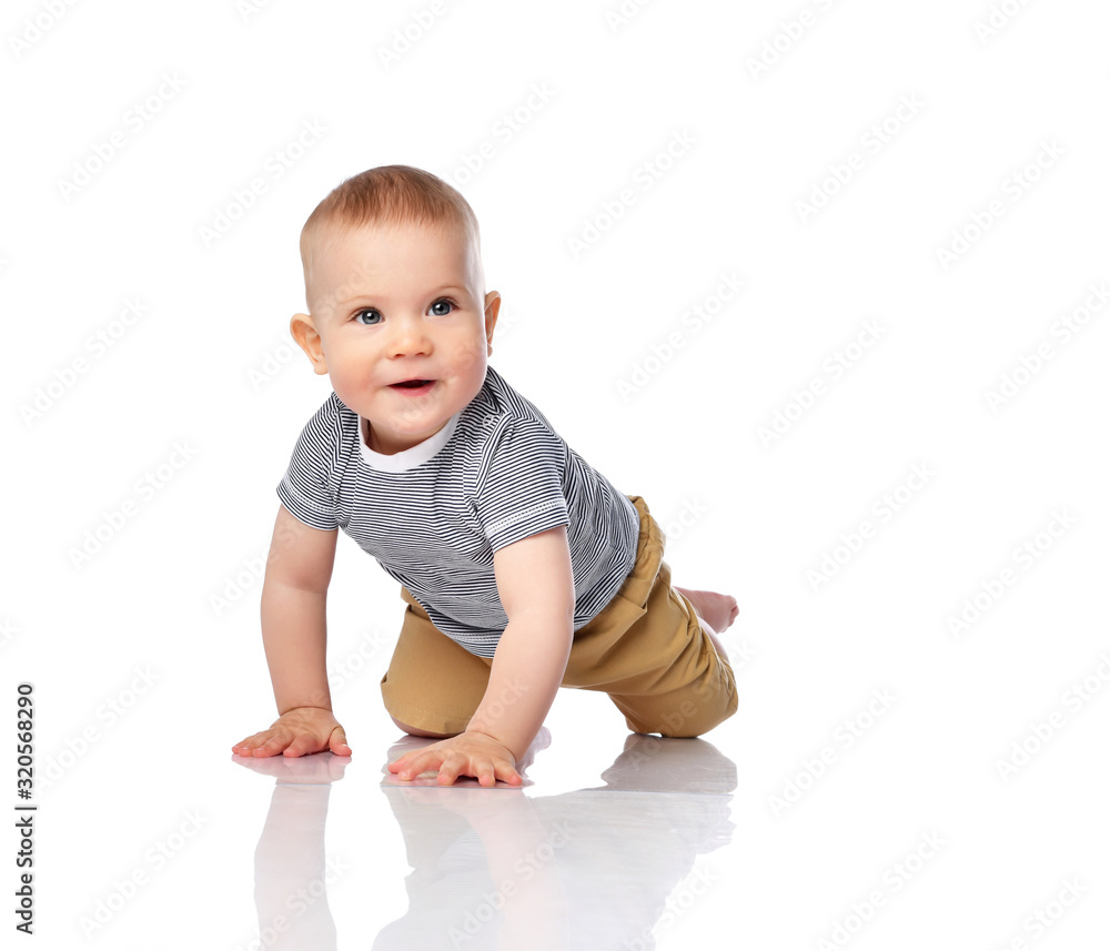 Curious infant boy toddler in t-shirt and green pants is crawling on all fours, looking copy space on white Curious infant boy toddler in t-shirt and green pants is crawling on all fours, looking copy space on white