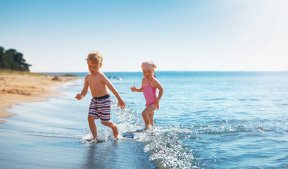 Boy and girl playing on the beach on summer holidays