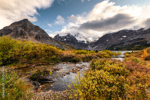 Mount Assiniboine with stream flowing in autumn forest at provincial park