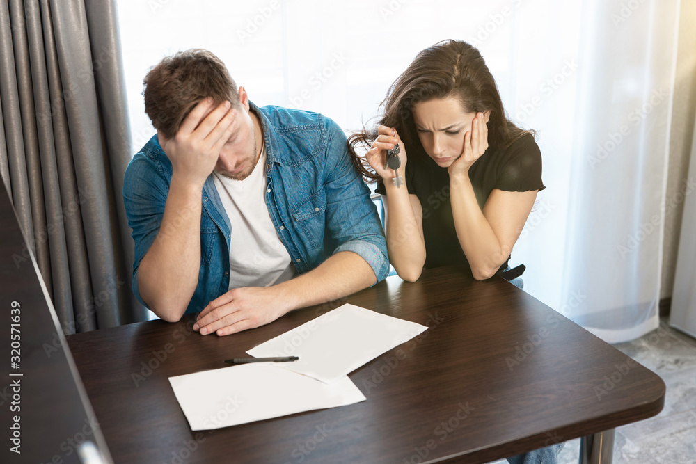 young loving couple man and woman looking exhausted, sitting together, studying layout of their new apartment , unforgettable moments young loving couple man and woman looking exhausted, sitting together, studying layout of their new apartment , unforgettable moments