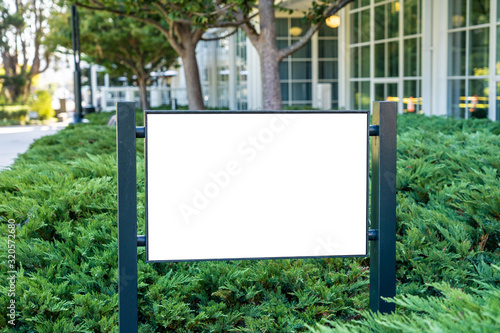 White company sign mockup in a garden