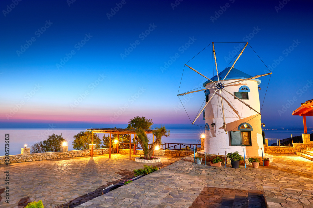 Traditional Wind Mills in Greece, Zakynthos Island. Incredibly romantic sunrise on Zakinthos. Amazing sunset view on old mill with multicolored clouds. Old Windmill in Agios Nikolaos near blue caves.